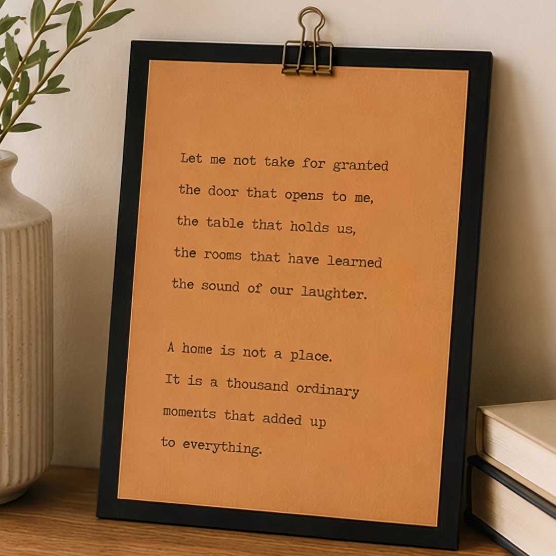 9x12 housewarming wood sign with kraft paper quote design displayed on a wooden table beside a neutral vase and books