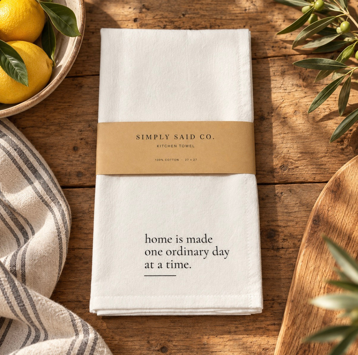 Home Is Made quote kitchen towel styled on a rustic wood kitchen table
