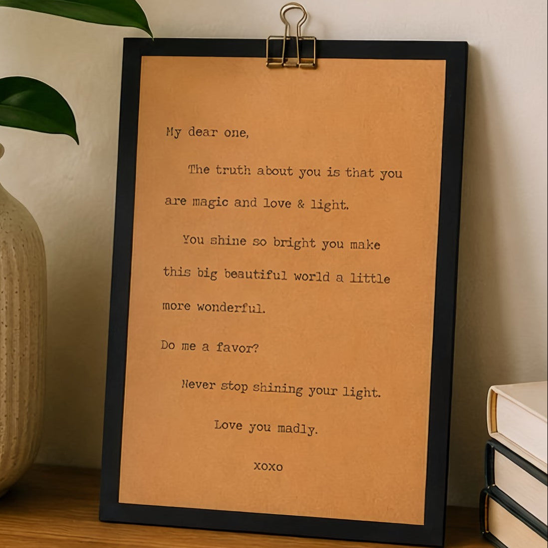 Meaningful encouragement quote wood sign with black border and kraft paper design styled beside a neutral vase, plant, and books