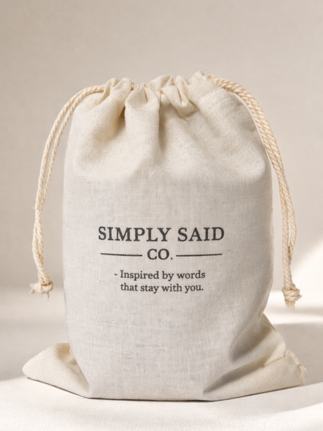 White drawstring bag with 'Simply Said Co.' text on a light background
