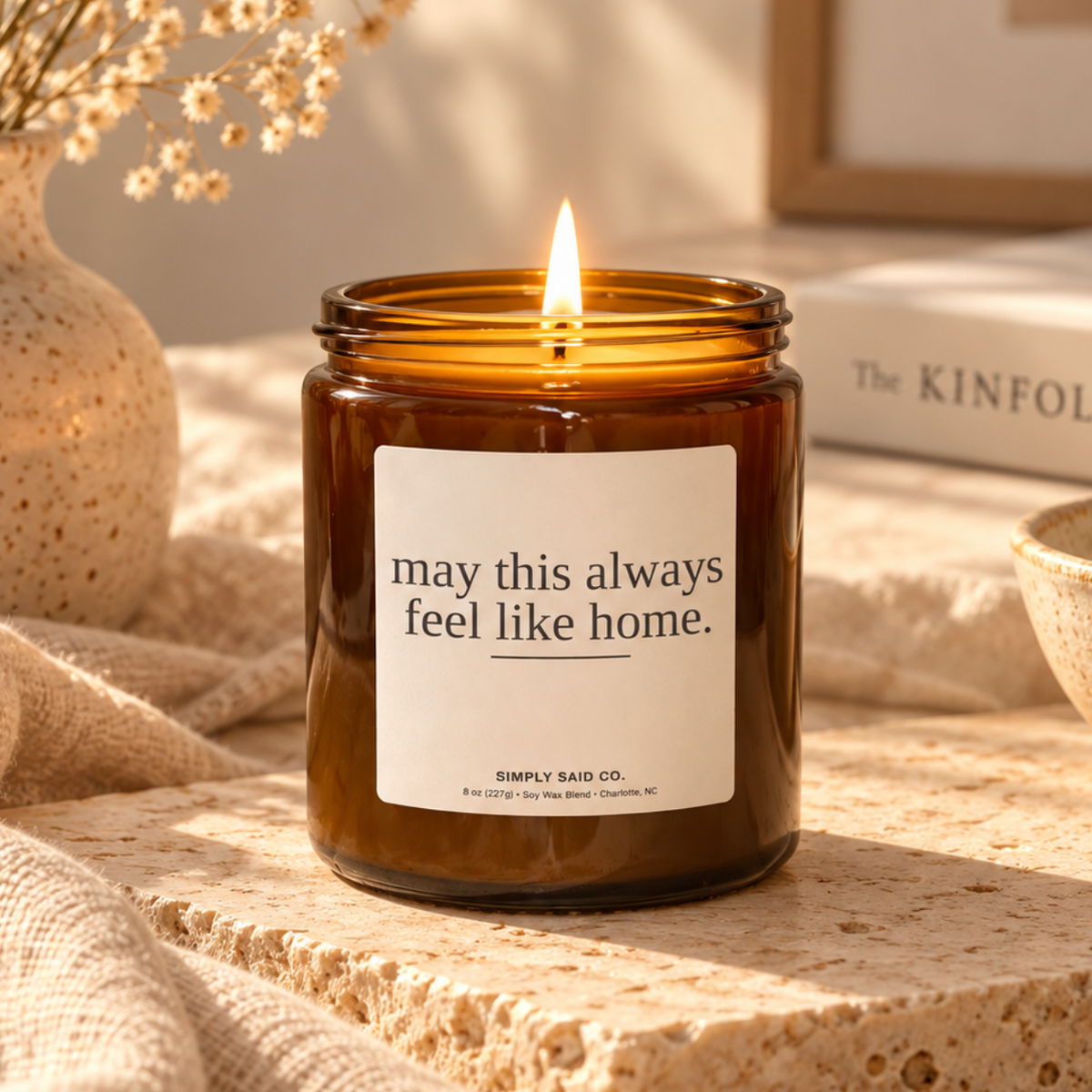 May This Always Feel Like Home soy candle styled in a warm neutral home setting